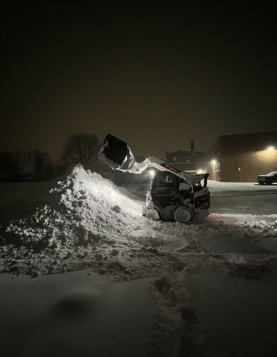 Snow removal equipment clearing snow at night by Weadickbros Snow & Ice Management
