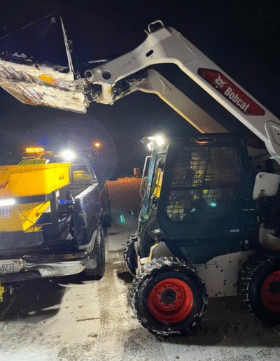Bobcat snow plow action at night by Weadickbros Snow & Ice Management