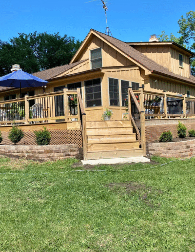 Wooden deck and landscaped yard at a home by Weadickbros Landscape Design & Build.