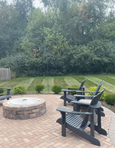 Cozy fire pit area with chairs and landscaped lawn by Weadickbros Lawn & Landscape.