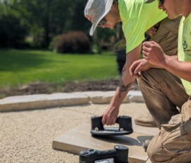 Pavers being carefully set in a backyard by Weadickbros Landscape Design & Build